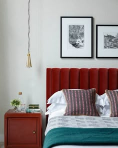 a bed with two framed pictures above it