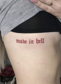 a woman with a tattoo that says made in hell on her side ribcage