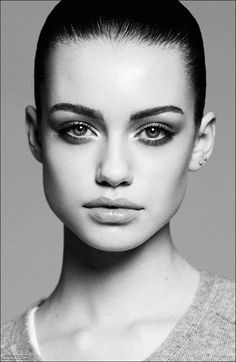 a black and white photo of a woman's face with dark eyeshadow