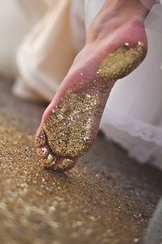 a person's foot covered in gold glitter