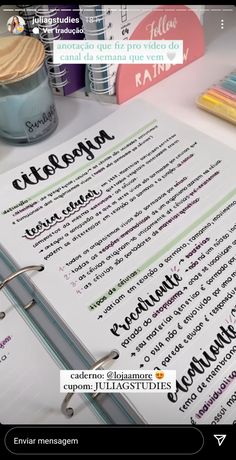 a close up of a book on a table with pens and paper next to it