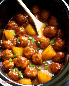 a crock pot filled with meatballs and pineapples, garnished with parsley