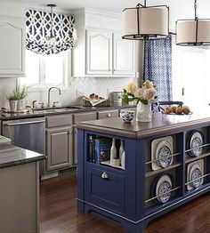 an image of a kitchen with blue island in the middle and white cabinets on the other side