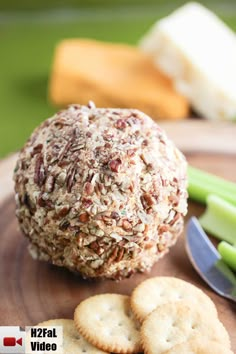 a ball of food sitting on top of a wooden plate next to crackers and celery