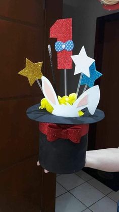 a person holding up a cake decorated with stars and bunny ears on top of it