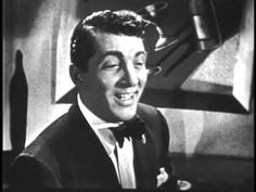 a man in a tuxedo smiles at the camera