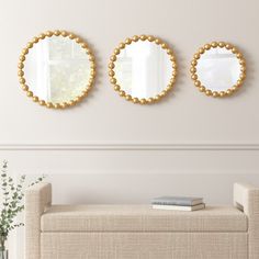 three circular mirrors on the wall above a bench