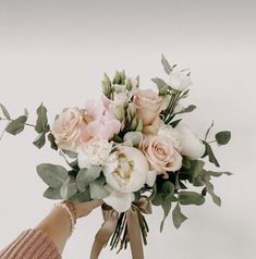 a woman holding a bouquet of flowers in her hand