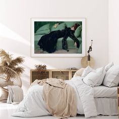 a bed with white sheets and pillows next to a painting on the wall above it