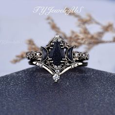 a black and white diamond ring sitting on top of a table