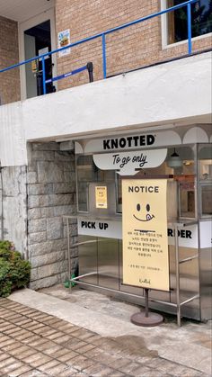 a sign on the side of a building that says knotted to go may notice pick up