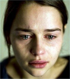 a woman with tears on her face looking at the camera