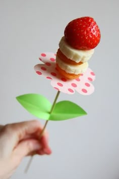 there is a small toy strawberry on top of a flower