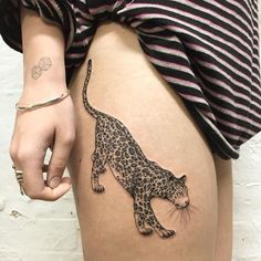 a woman's thigh with a tattoo of a leopard on it