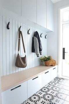 a coat rack with two coats hanging on it and some purses sitting on the shelf