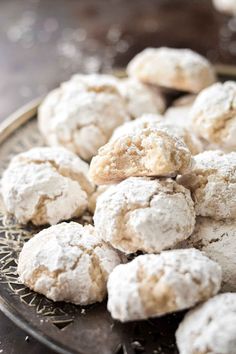 some powdered sugar cookies are on a metal platter and ready to be eaten