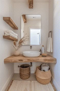 a bathroom with a sink, mirror and two baskets on the floor in front of it