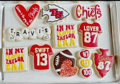 decorated cookies in the shape of football jerseys and numbers are displayed on a platter