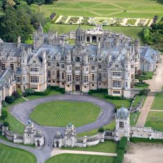 an aerial view of a large castle with lots of windows and grass in the foreground