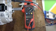 an electrical tester sitting on top of a wooden table next to a wrench