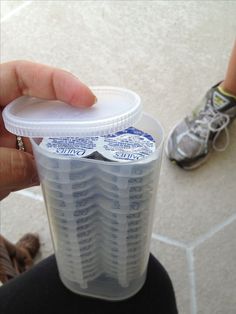 a person holding a plastic container with several pairs of shoes in it