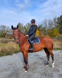 a woman riding on the back of a brown horse