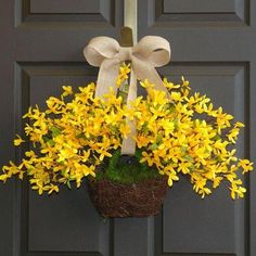 yellow flowers in a basket hanging on the front door