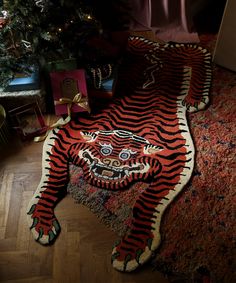 a tiger rug on the floor next to a christmas tree