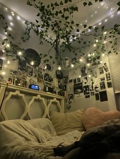 an unmade bed with lots of lights hanging from the ceiling and ivy growing over it