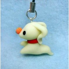 a keychain shaped like a dog with an orange nose