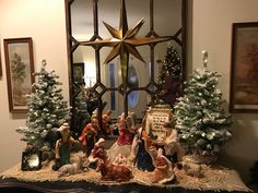 a nativity scene with figurines and christmas trees