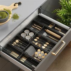 the drawer is open to reveal an assortment of utensils and other kitchen items