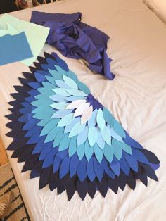 a bed topped with blue and green paper wings