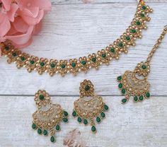 Beautiful Indian Bollywood choker necklace jewellery set with tikka headpiece & earrings.  Gold base with light antique gold & green stones.  Detailed with intricate pearl details to make this just so elegant.  Earring drop is: 5 cm  Perfect piece for bridesmaids and simple party guest wear.