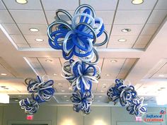 blue and white decorations hanging from the ceiling in an office building with lights above them