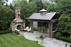 an outdoor fireplace and grill in the middle of a yard