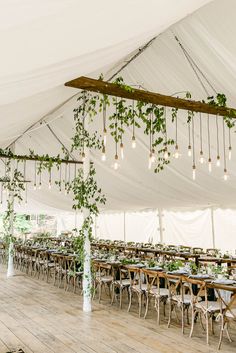 the inside of a tent with tables and chairs set up for an outdoor wedding reception