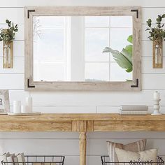 a wooden table sitting under a mirror on top of a wall