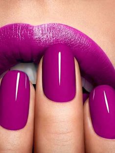 a woman's hand with purple nail polish on her nails and a pink lip