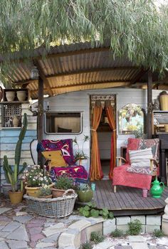 an outdoor living area with couches and potted plants