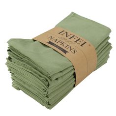 green napkins stacked on top of each other with a brown paper tag attached to them