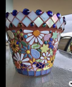 a colorful glass vase sitting on top of a counter next to a window sill