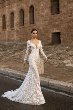 a woman in a wedding dress standing on the street