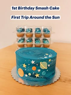 a birthday cake with blue frosting and stars on it, surrounded by cupcakes