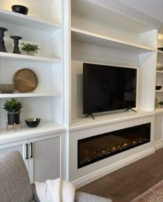 a living room filled with furniture and a flat screen tv mounted on a wall above a fire place