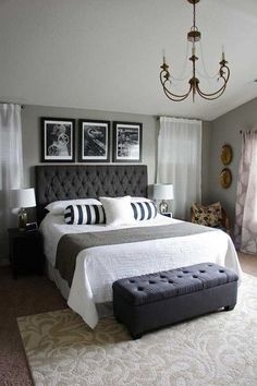 a bedroom with a large bed, chandelier and pictures on the wall above it