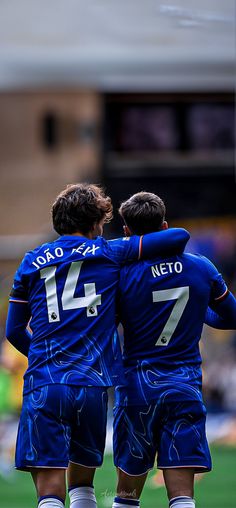 two soccer players are hugging each other on the field