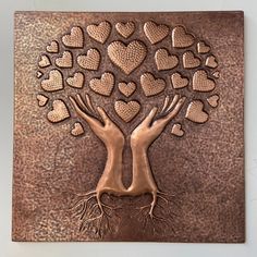 a metal plaque with hearts on it and two hands holding each other's arms