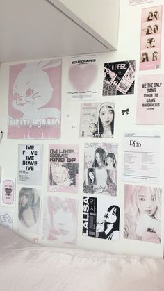 a wall covered in posters and stickers next to a bed with sheets on it