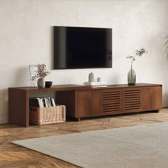 a flat screen tv sitting on top of a wooden entertainment center in a living room